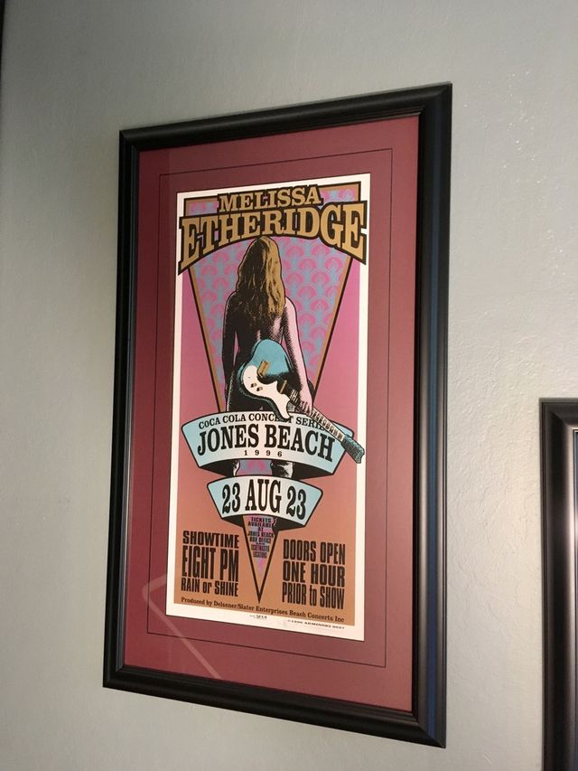 A Melissa Etheridge Jones Beach concert poster in a black frame with a red mat