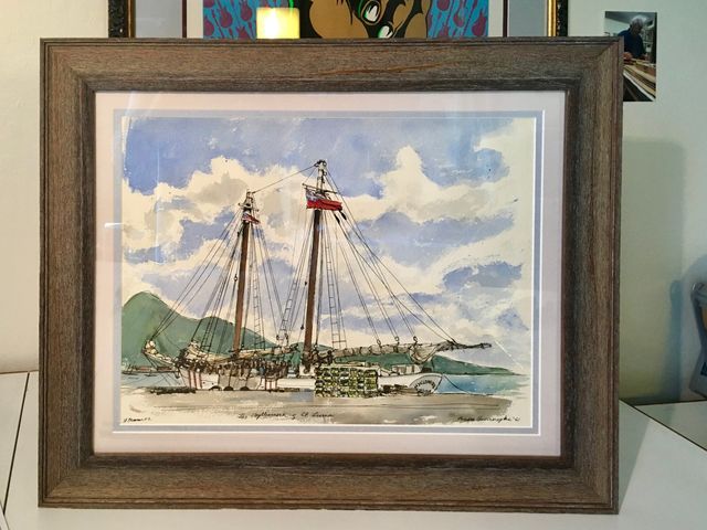 A watercolor of a tall sailing ship in a harbor, in a rustic wood frame with a white mat