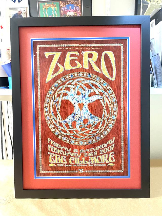 A red and blue Zero concert poster from the Fillmore in a black frame with a red mat
